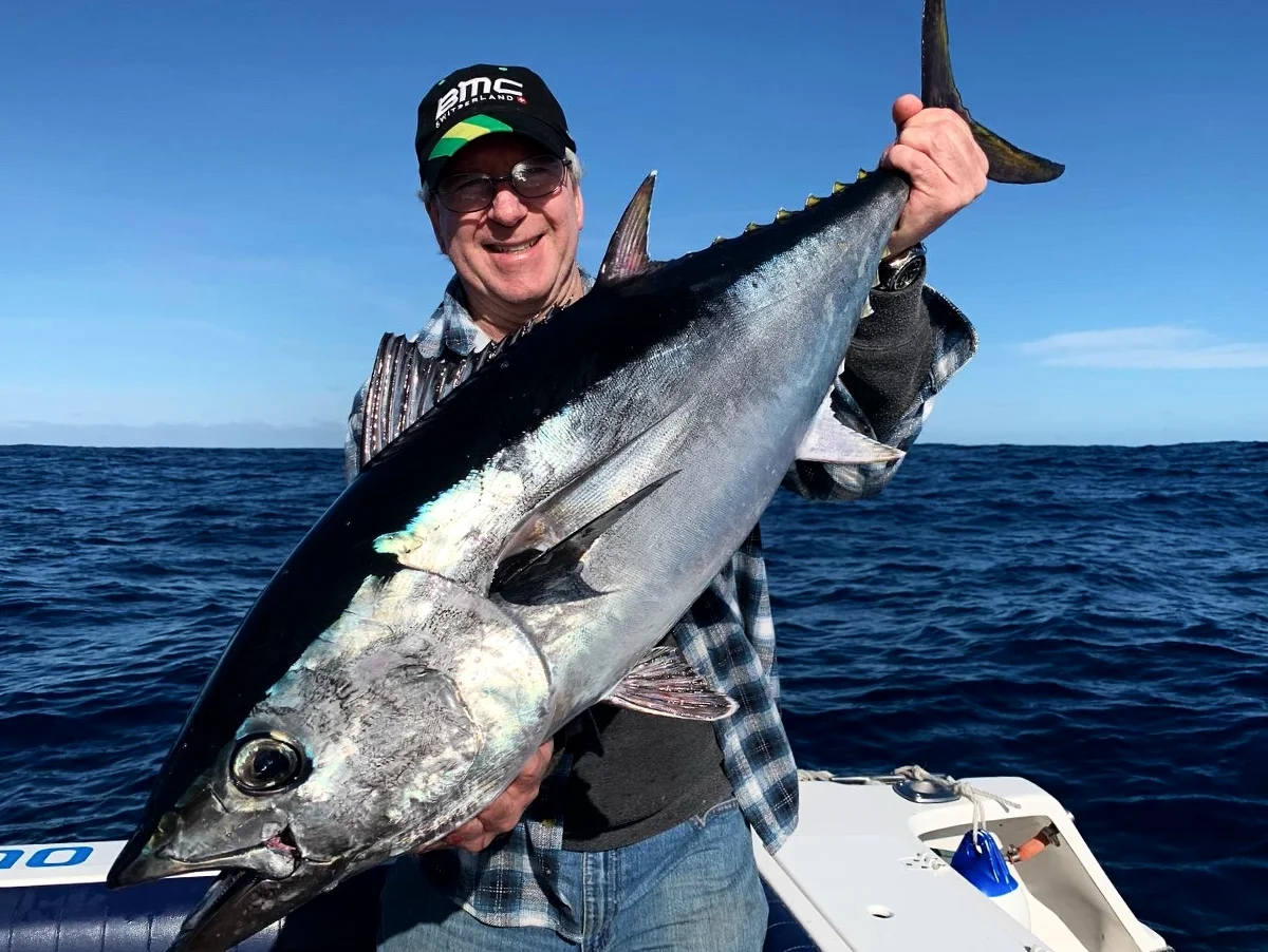 Angler smiling behind a big tuna caught on a GT Fishing Charters trip